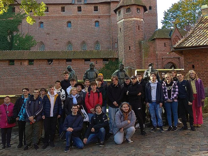 grupa uczniów na tle Zamku Krzyżackiego w Malborku